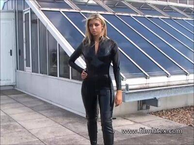 Blonde latex-babes outdoor knee boots and high heels of fetish girl in tight full body rubber outfit with softcore glamour model Karina outside on the roof on freereelz.com