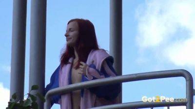 Watch this kinky redhead get a public surprise while peeing in the city on freereelz.com