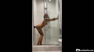 Tattooed teen gril fucking her sex toy in the shower on freereelz.com