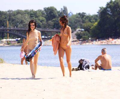 Petite nudist teen enjoys a beautiful day at the beach on freereelz.com