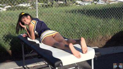 Cheerleader without panties sunbathing on the massage table on freereelz.com