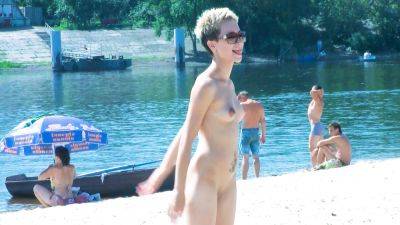 Nude beach girl chats with her friends lays naked and enjoys the sun on freereelz.com